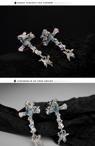 Macro detail of irregular silver cross earring with light blue opal and dragonfly charm