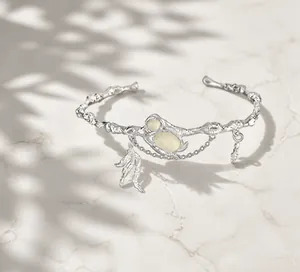 Artistic silver branch-textured cuff bracelet with white cabochons and feather charms