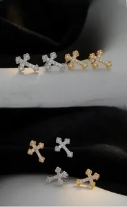 Close-up of S925 silver cross stud earrings with sparkling cubic zirconia and milgrain edge