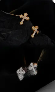 Detailed view of gold and silver cross stud earrings with sparkling cubic zirconia stones