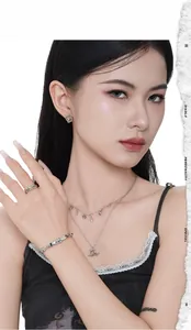 Close-up of a model wearing a set of S925 sterling silver cat-shaped stud earrings and rings