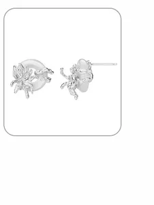 Detailed view of silver spider earring crawling on a white circular stone stud