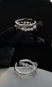 Macro detail of S925 sterling silver cross ring with lava texture and white pearls