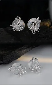 Macro detail of S925 silver spider wrap earring on a frosted peace buckle ring