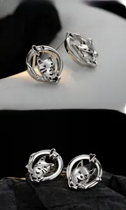 Detail shot of 925 sterling silver cat stud earrings with black enamel facial features