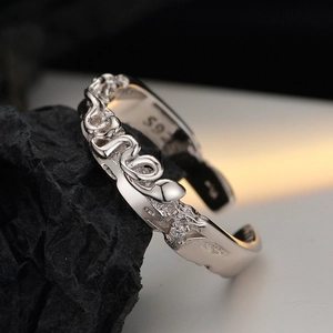 S925 sterling silver snake ring with wavy texture and small zircon on a dark background