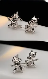 Macro detail of S925 sterling silver cat earrings playing guitar with polished finish