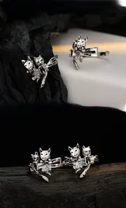 Detailed view of two vintage oxidized silver cat rings on a textured black background