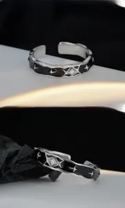 Macro shot of S925 silver ring featuring black enamel stars and a central zircon stone