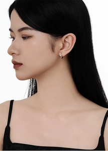 Détail de la boucle d'oreille étoile en argent S925 avec zircon brillant portée à l'oreille
