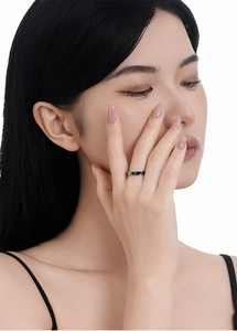Detail of minimalist S925 silver ring with black enamel and star pattern on model's hand