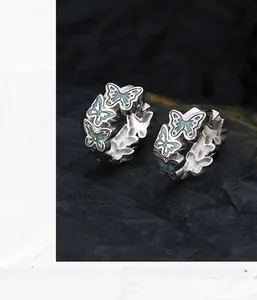 Macro detail of S925 sterling silver hoop earrings with blue enamel butterfly design