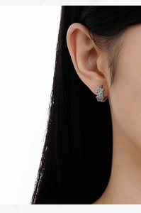 Close-up of S925 silver hoop earrings with blue enamel butterfly design on a model