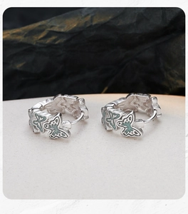 Detail of S925 silver hoop earrings with mint green enamel butterfly charms
