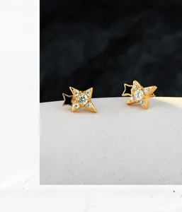 Detail of star-shaped stud earrings with gold plating, cubic zirconia, and black enamel inlay