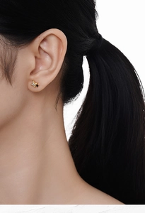 Close-up of gold star earrings with zircon inlay worn by a model for a stylish look