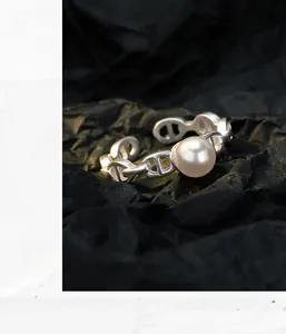 Macro shot of S925 silver anchor chain ring with an elegant round freshwater shell pearl