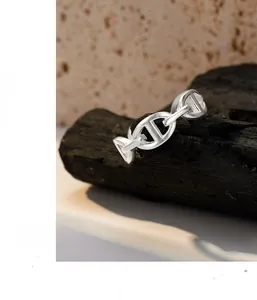 Macro detail of silver matte chain link ring displayed on a dark stone background