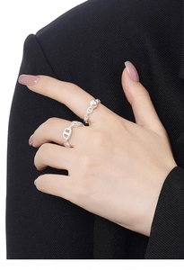Close-up of S925 sterling silver chain rings with pearl on a model in a black suit