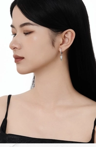 Dettaglio di orecchini a cono in argento sterling S925 con cristalli pavé su una modella