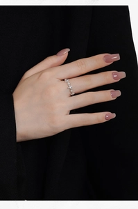 Close-up of S925 sterling silver beaded ring worn on index finger against black suit