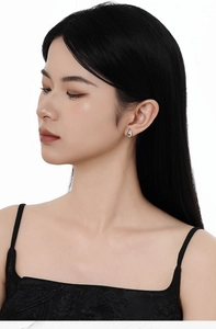 Gros plan de boucles d'oreilles gouttes minimalistes en argent 925 portées par un mannequin