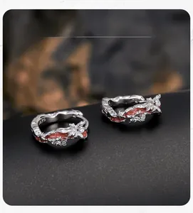 Macro detail of S925 sterling silver butterfly earrings with orange enamel and zircon inlay