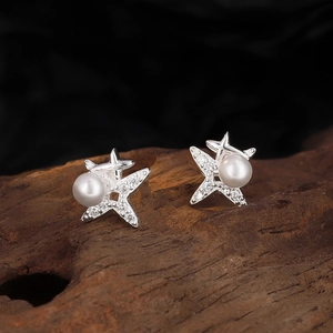 S925 sterling silver star stud earrings with pearl and zircons on a wooden block