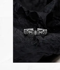 Close-up of vintage S925 silver ring featuring intricate floral carvings and zircon stones