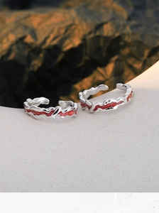Detailed view of silver irregular ear cuffs with pink enamel in artistic wavy design
