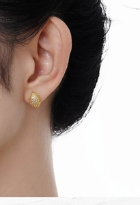 Close-up of minimalist gold-plated S925 silver oval stud earrings with pavé zircons