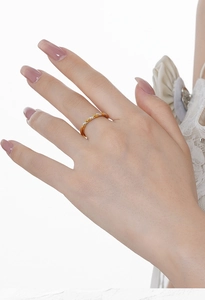 Detail of mixed-tone rope ring with pavé stones shown on finger with lace accents