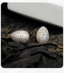 Macro detail of egg-shaped S925 sterling silver stud earrings with pave setting zirconias