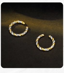 Detailed view of two-tone twisted rope ear cuffs with high-polished gold and silver finish