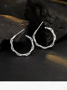 Close-up of S925 sterling silver C-shaped hoop earrings with woven chain texture and hollow design