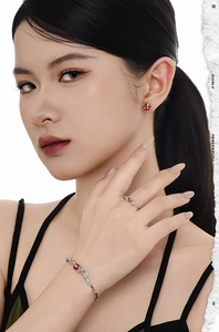 Detail shot of silver snake jewelry set with red enamel accents worn by a model