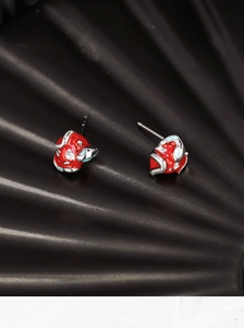 Macro detail of 925 silver snake wrapping red apple stud earrings with enamel finish