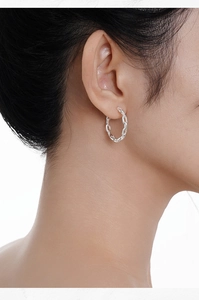Close-up of minimalist S925 sterling silver chain earrings worn by a model