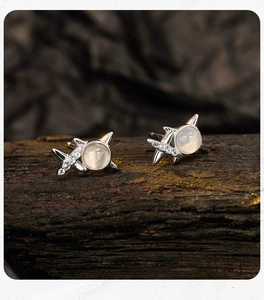 Macro shot of silver cat-ear earrings with moonstone and sparkling pavé diamonds