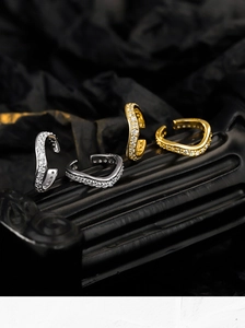 Detailed close-up of gold and silver geometric ear cuffs with sparkling cubic zirconia