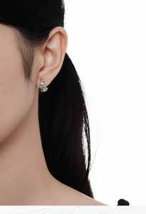 Gros plan de boucles d'oreilles étoile en argent S925 avec zircon portées à l'oreille