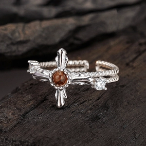 Vintage S925 sterling silver cross ring with brown gemstone on rustic wood background