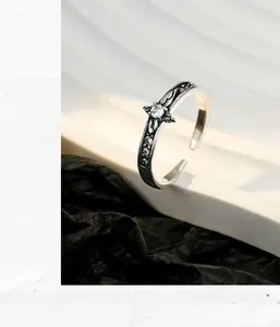 Macro detail of retro S925 sterling silver ring with oxidized floral texture and zircon