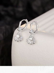 Detailed macro of S925 silver earring featuring shell pendant with pearl and blue zircon