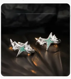 Détail des boucles d'oreilles étoile en argent S925 avec émail vert et zircons