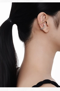 Close-up of sparkling S925 silver and gold ear cuffs set with zircon on female model