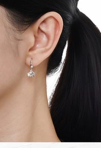 Close-up of S925 silver shell earrings with white pearl detail worn by a model