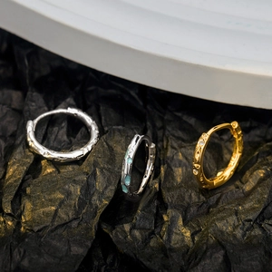 Trois créoles en argent sterling S925 avec émail et zircon sur fond de papier texturé