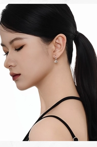 Close-up of S925 sterling silver shell earrings with white pearl on a model's ear