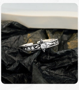 Macro detail of vintage oxidized S925 silver ring with star zircon and petal design
